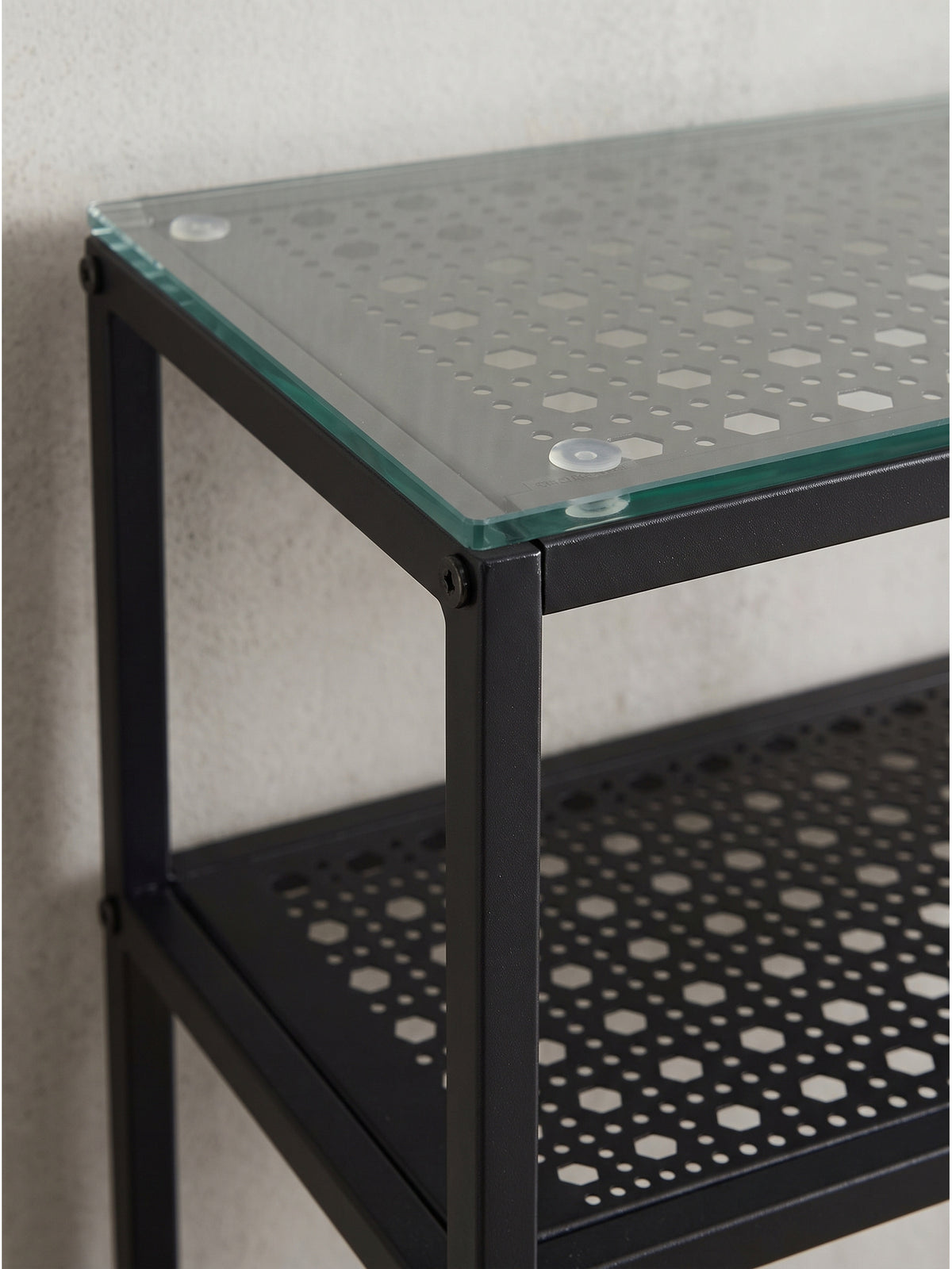 Geometrischer Konsolentisch im reduzierten Minimalismus-Stil mit klaren Linien aus Glas und schwarzem Metall im leeren Raum_