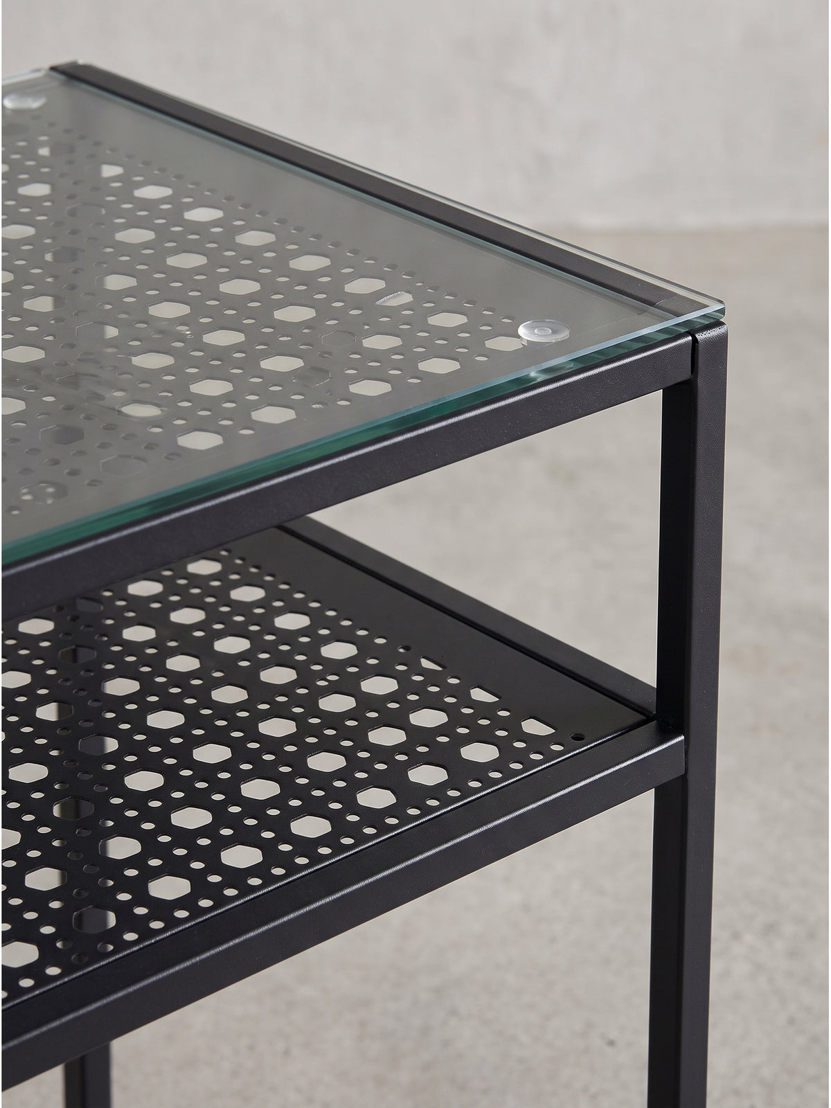 Schlichter Design-Ablagetisch für schmale Flure mit schwarzem Lochblech als zweite Ebene direkt unter der glatten Glasoberfläche_
