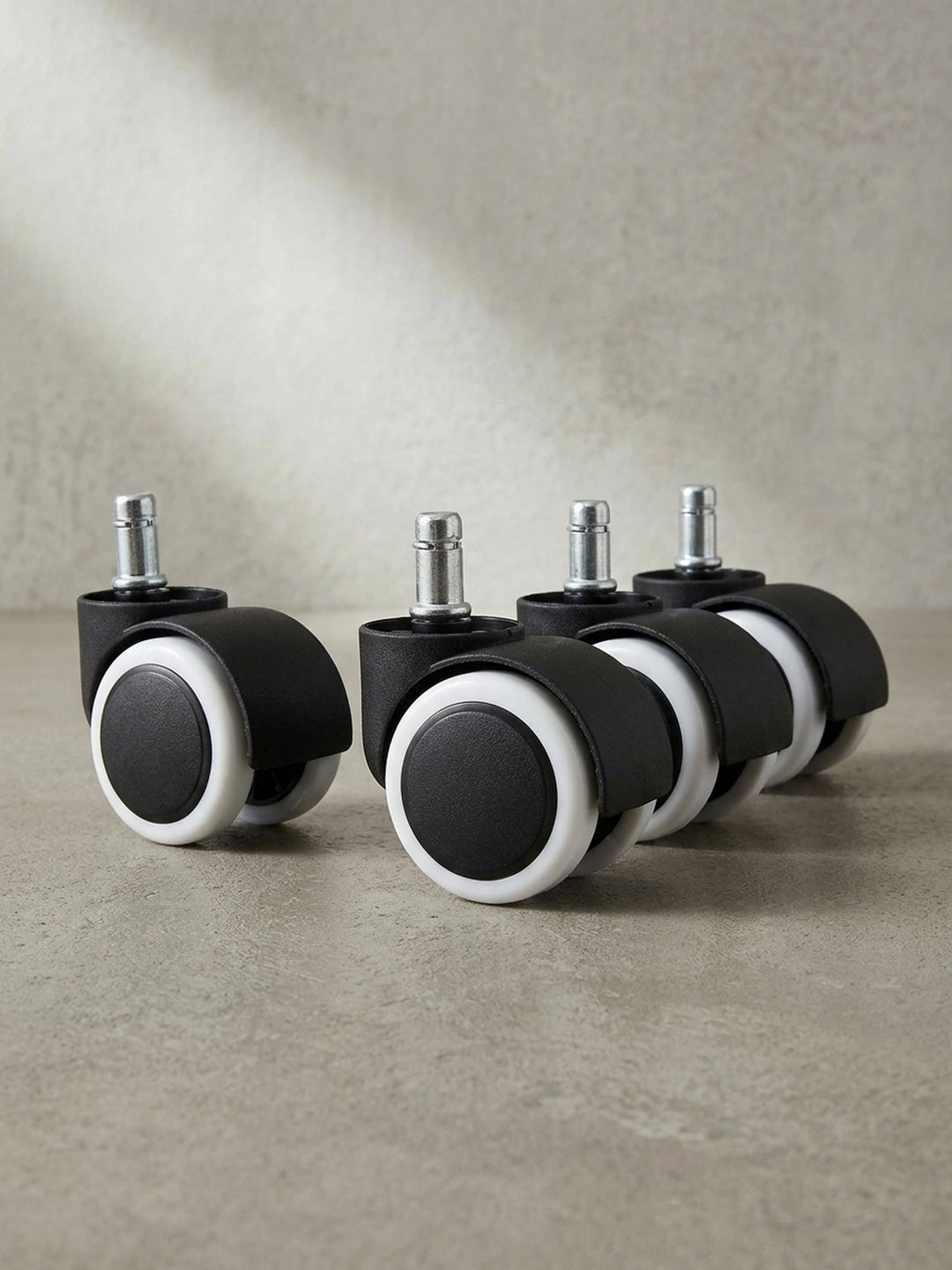 Leicht seitliche Perspektive der Hartbodenrollen, die die robuste Kunststoffkonstruktion und das Doppelrad-Design zeigt._