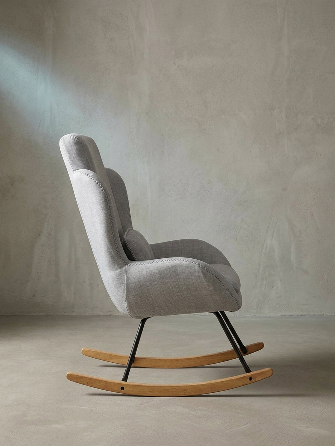 Schrägansicht des eleganten grauen Lesestuhls mit dickem Sitzpolster auf weißem Hintergrund für fokussiertes Interior Design._