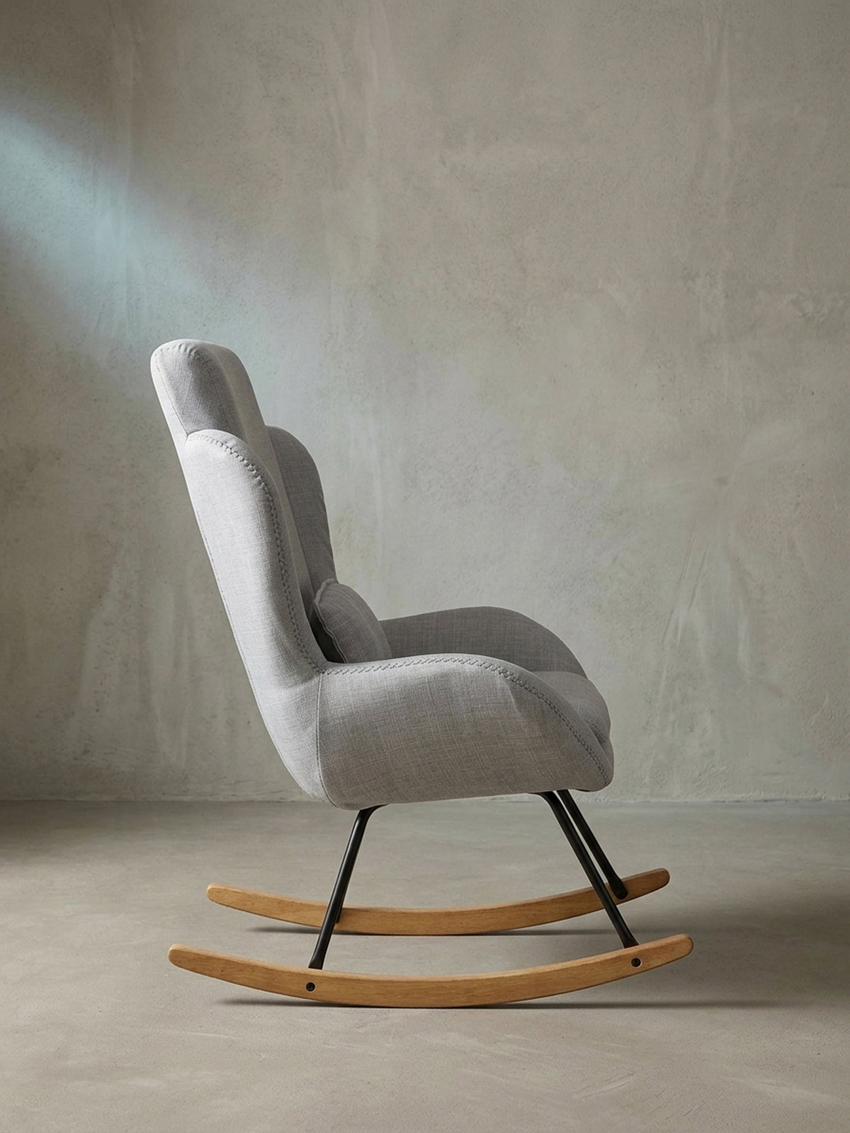 Schrägansicht des eleganten grauen Lesestuhls mit dickem Sitzpolster auf weißem Hintergrund für fokussiertes Interior Design._