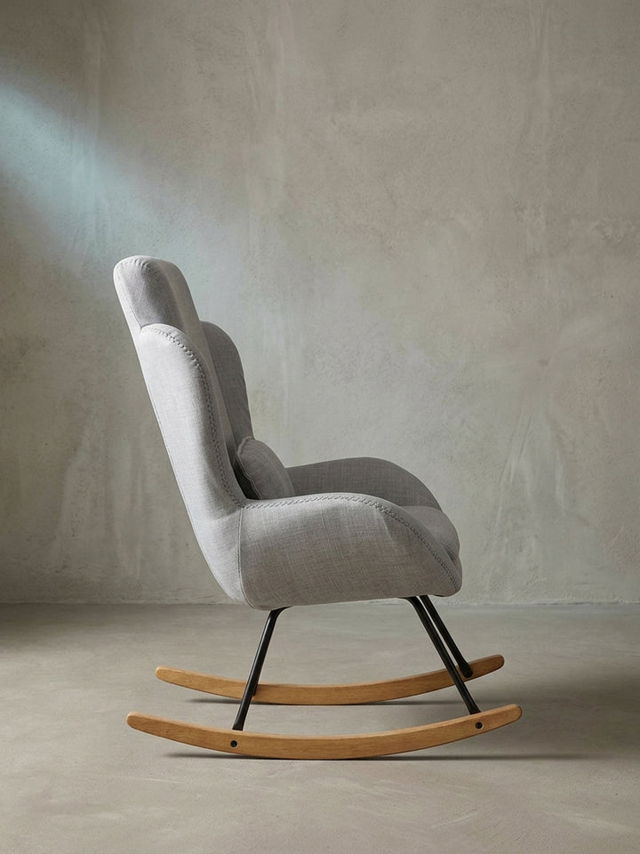 Schrägansicht des eleganten grauen Lesestuhls mit dickem Sitzpolster auf weißem Hintergrund für fokussiertes Interior Design._