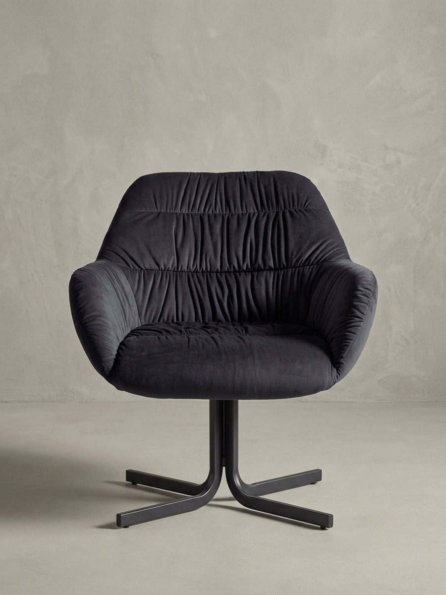 Profilansicht des schwarzen Samtsessels, bei der die ergonomische Neigung der Rückenlehne und die robuste Konstruktion des zentralen Metallgestells sichtbar sind._