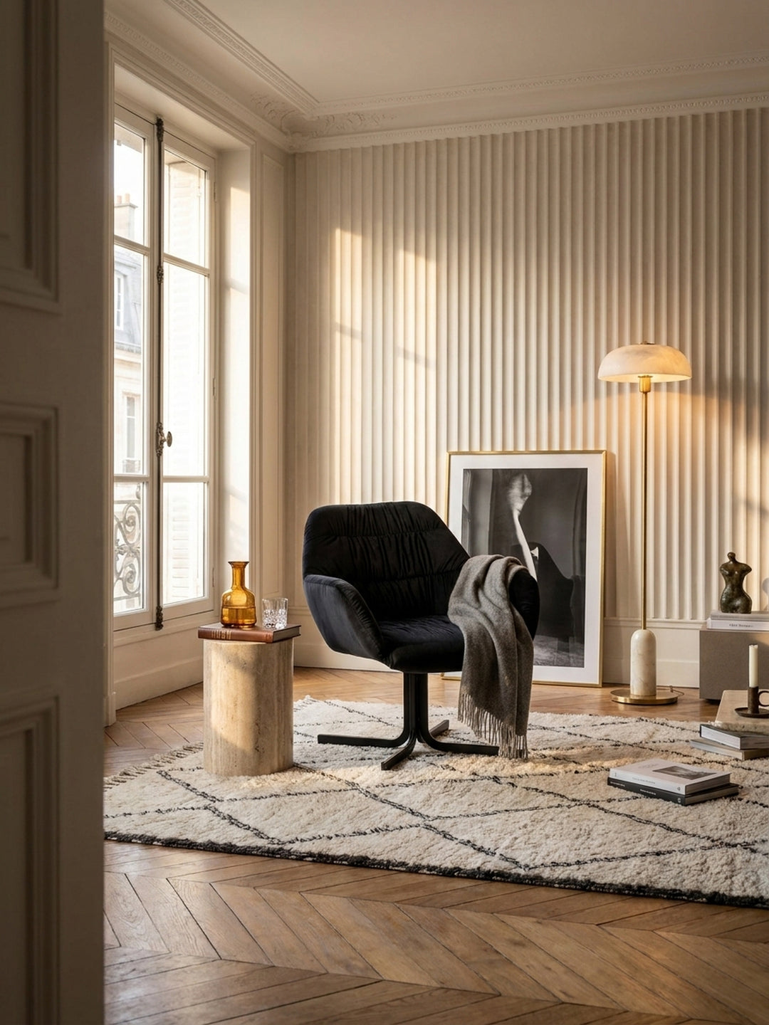 Schwarzer Cocktailsessel aus weichem Samt mit markanter Raffung in einem luxuriösen modern-classic Wohnzimmer mit hellem Eichenparkett und warmen Travertin-Akzenten._