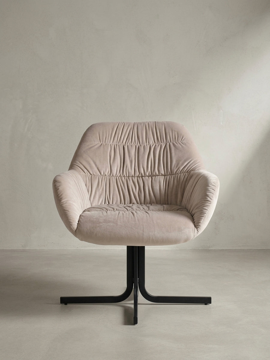 Schrägansicht des eleganten Cocktailsessels in Beige mit umschließender Rückenlehne und pulverbeschichteten schwarzen Beinen._