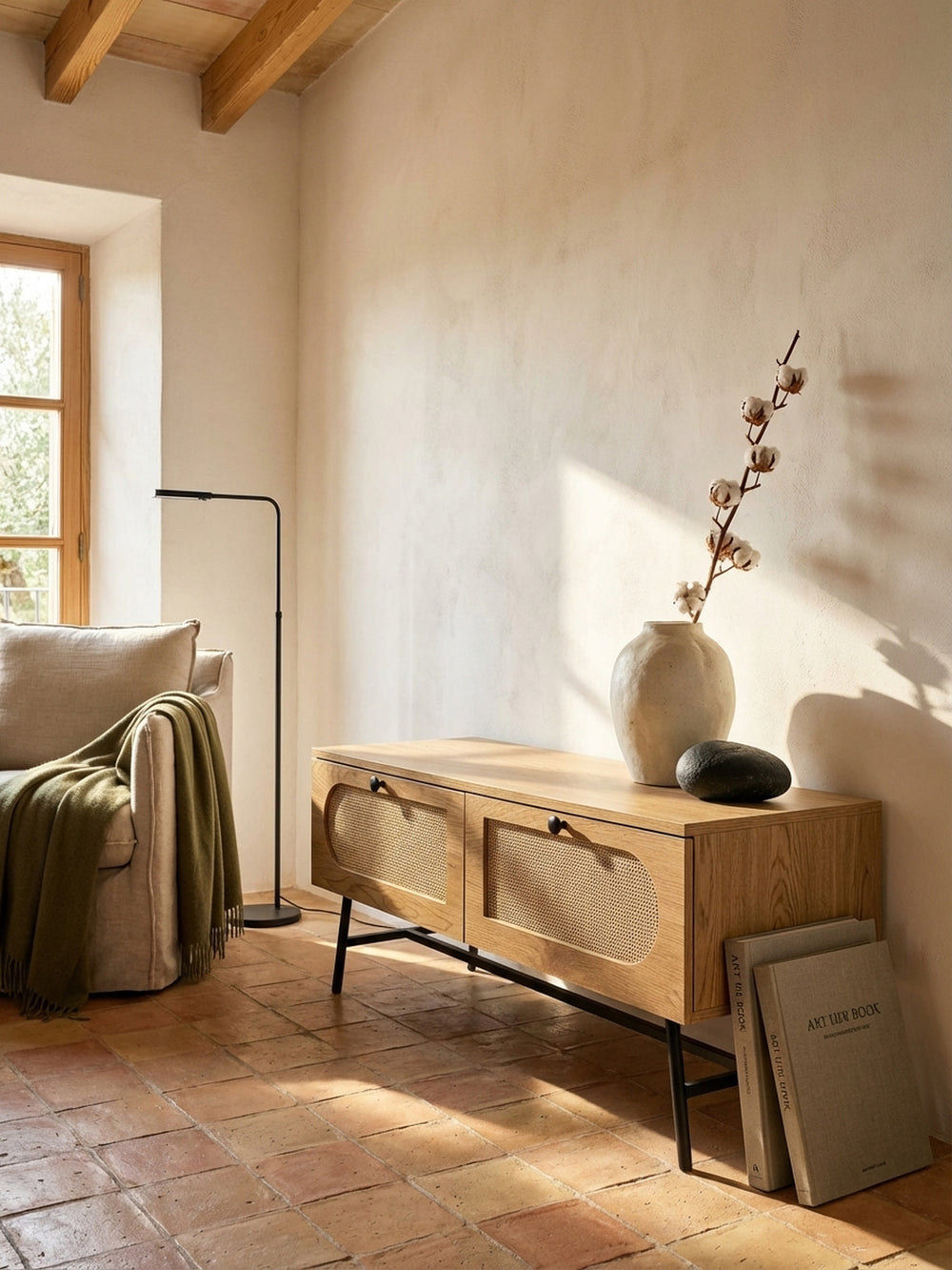 Das Rattan-TV-Board in Kombination mit einem beigefarbenen Lehnensessel und einer schwarzen Stehlampe für ein harmonisches Wohnkonzept._