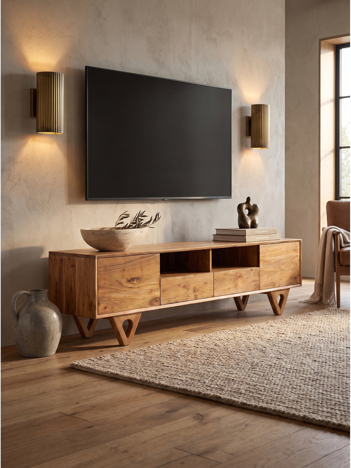 Dekoriertes TV-Board aus massiver Akazie mit einer schweren Travertinschale und getrockneten Olivenzweigen im ruhigen Zuhause._