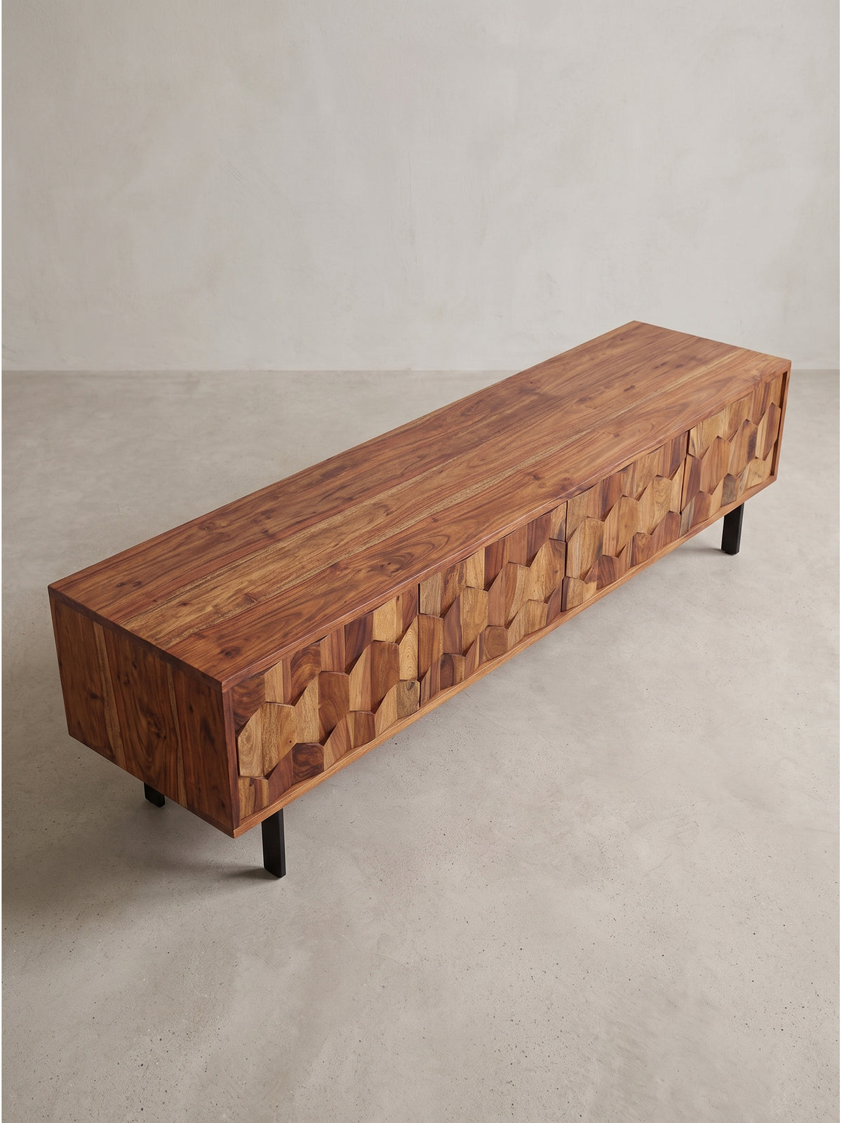 Elegantes Massivholz Lowboard in 3/4 Ansicht mit Fokus auf die skulpturalen Holzfronten und filigranen Beine_
