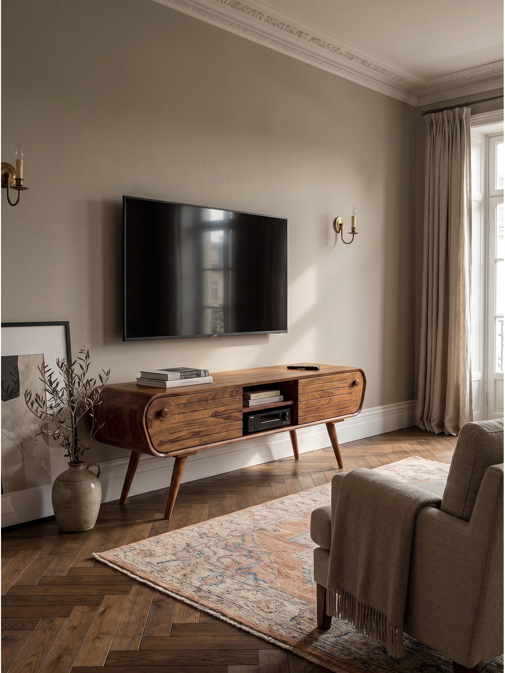 Mid-Century TV Lowboard aus Sheesham Massivholz 160x45x50 cm im stilvollen Wohnzimmer auf antikem Oushak Teppich vor einer strukturierten Wand._