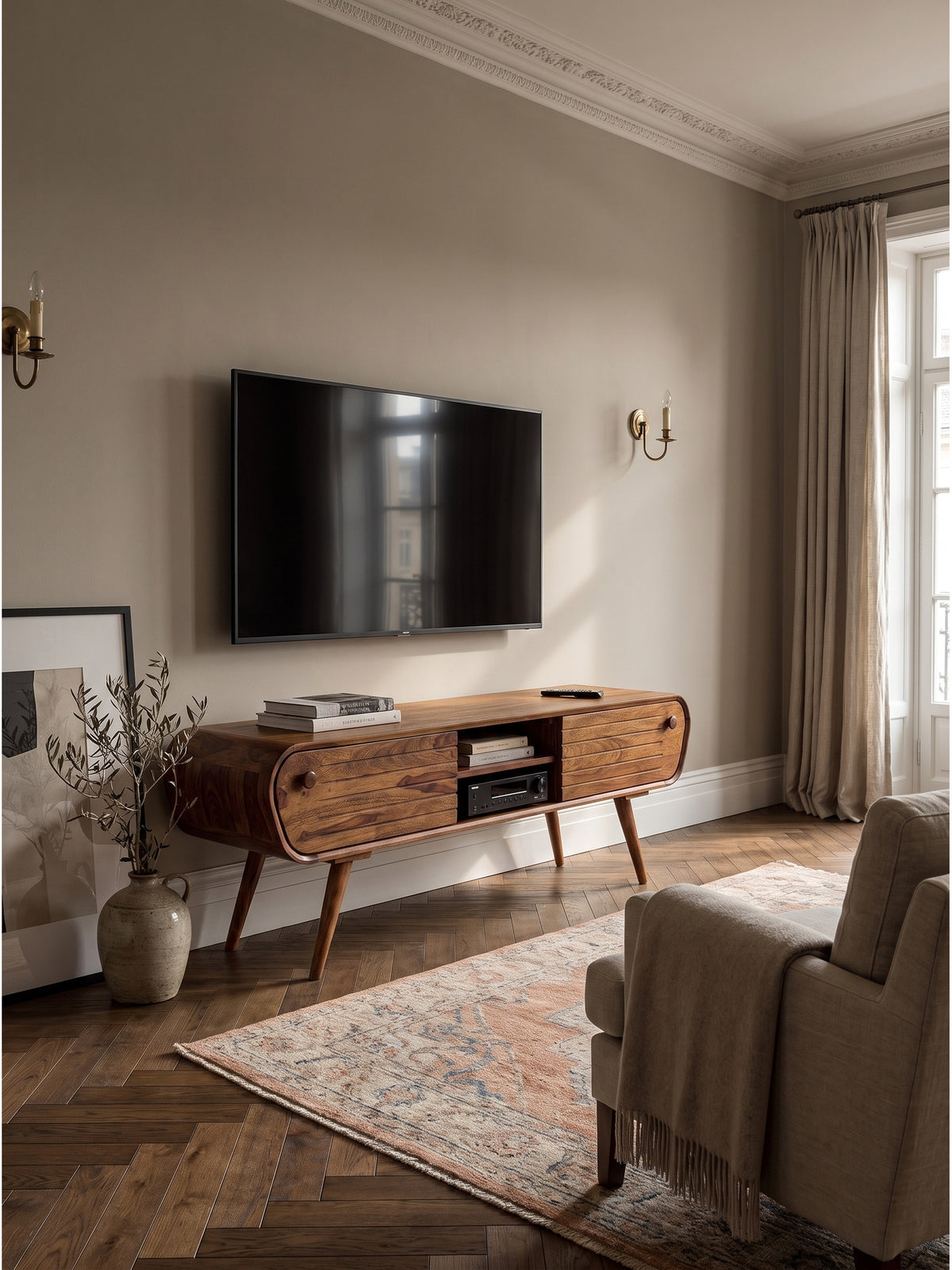 Mid-Century TV Lowboard aus Sheesham Massivholz 160x45x50 cm im stilvollen Wohnzimmer auf antikem Oushak Teppich vor einer strukturierten Wand._