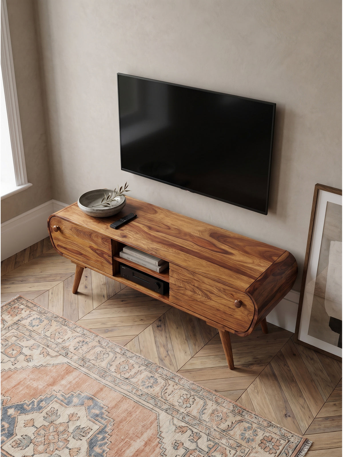Draufsicht auf das handgefertigte Fernsehtisch Holz Möbelstück mit abgerundeten Ecken im Vintage Design neben einem Ledersessel.
