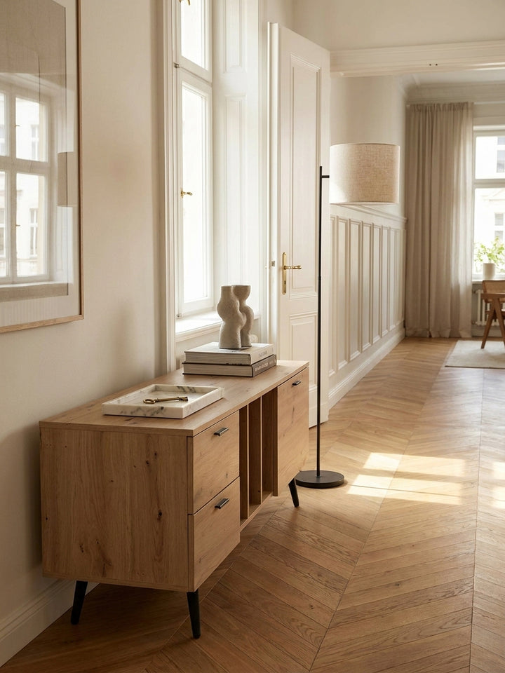 Kombination aus Fernsehkommode in Holzoptik und einem gemütlichen grauen Sofa im modernen Wohnbereich mit Fischgrätparkett._