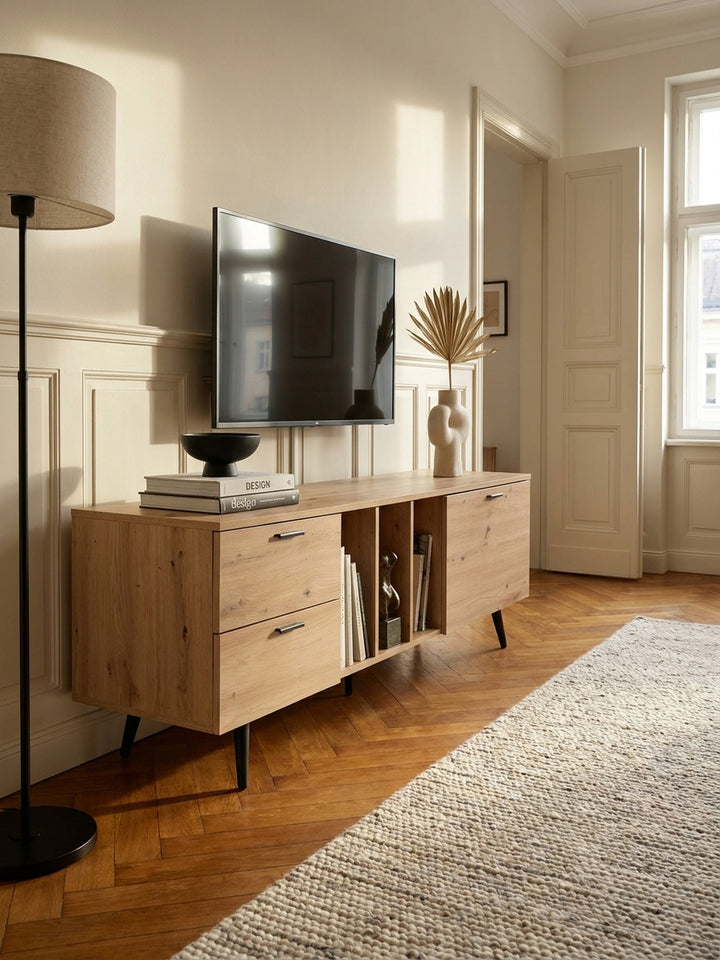 Nahaufnahme der Holzmaserung des folierten Eiche-Dekors mit mattschwarzem Metallgriff an der Schublade des Fernsehschranks._
