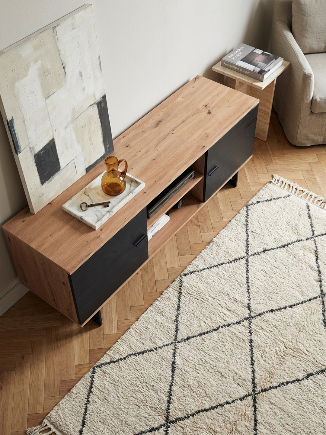 Luftige Raumaufteilung im Wohnbereich von oben gesehen mit einem 150 cm breiten Fernsehschrank und einem hellen Beni-Ourain-Teppich._