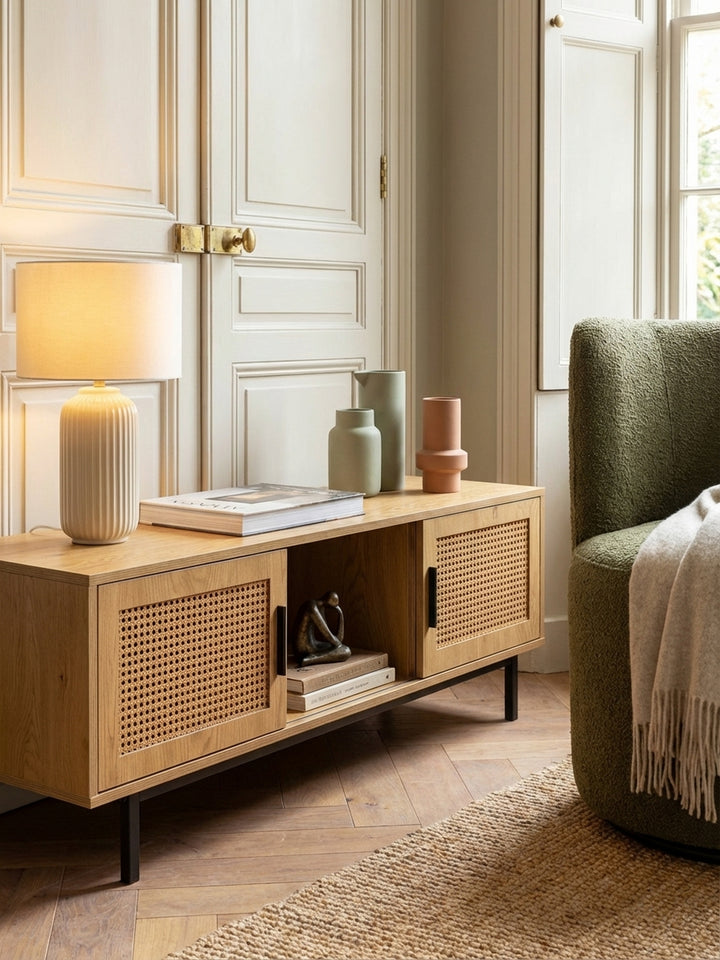Einrichtungsidee für den TV-Schrank: Eine Keramiklampe und Kunstbücher schmücken die Oberfläche des Lowboards und schaffen eine gemütliche Atmosphäre im Wohnzimmer._