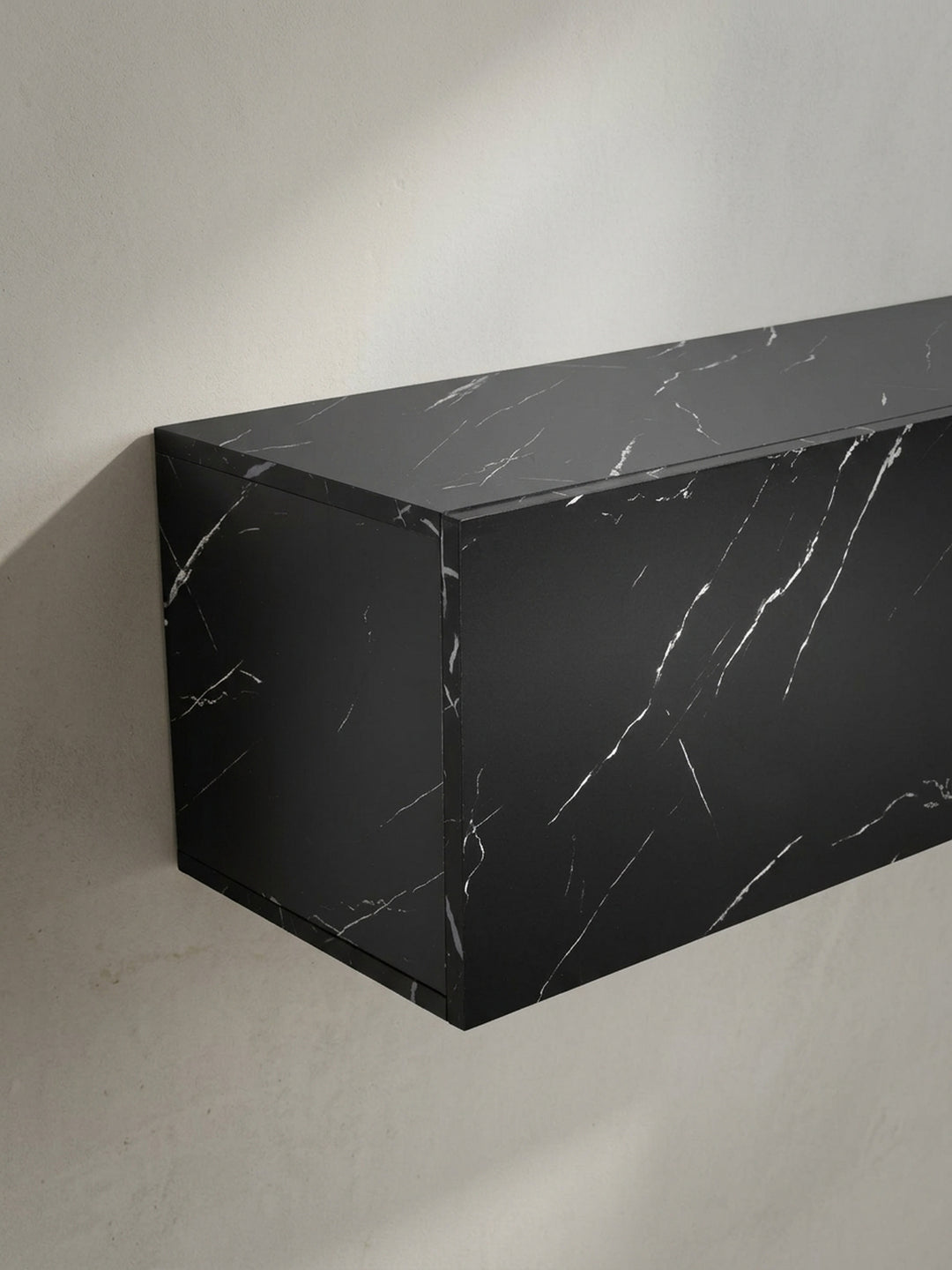 Perspektivische Ansicht von oben auf den schwarzen Design Fernsehtisch, die die großzügige Ablagefläche von 120x30 cm für Deko und Geräte zeigt._