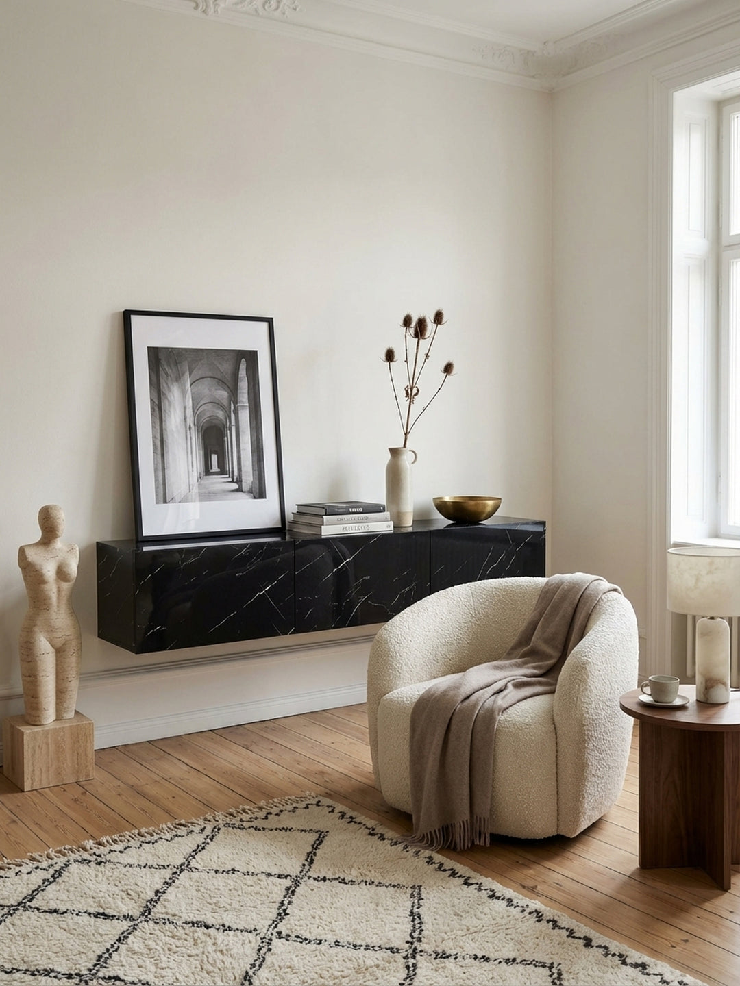 Das hängende TV-Lowboard in schwarzer Marmor-Optik harmoniert mit einem modernen Ledersessel und minimalistischer Wanddekoration in einem stilvollen Wohnambiente._