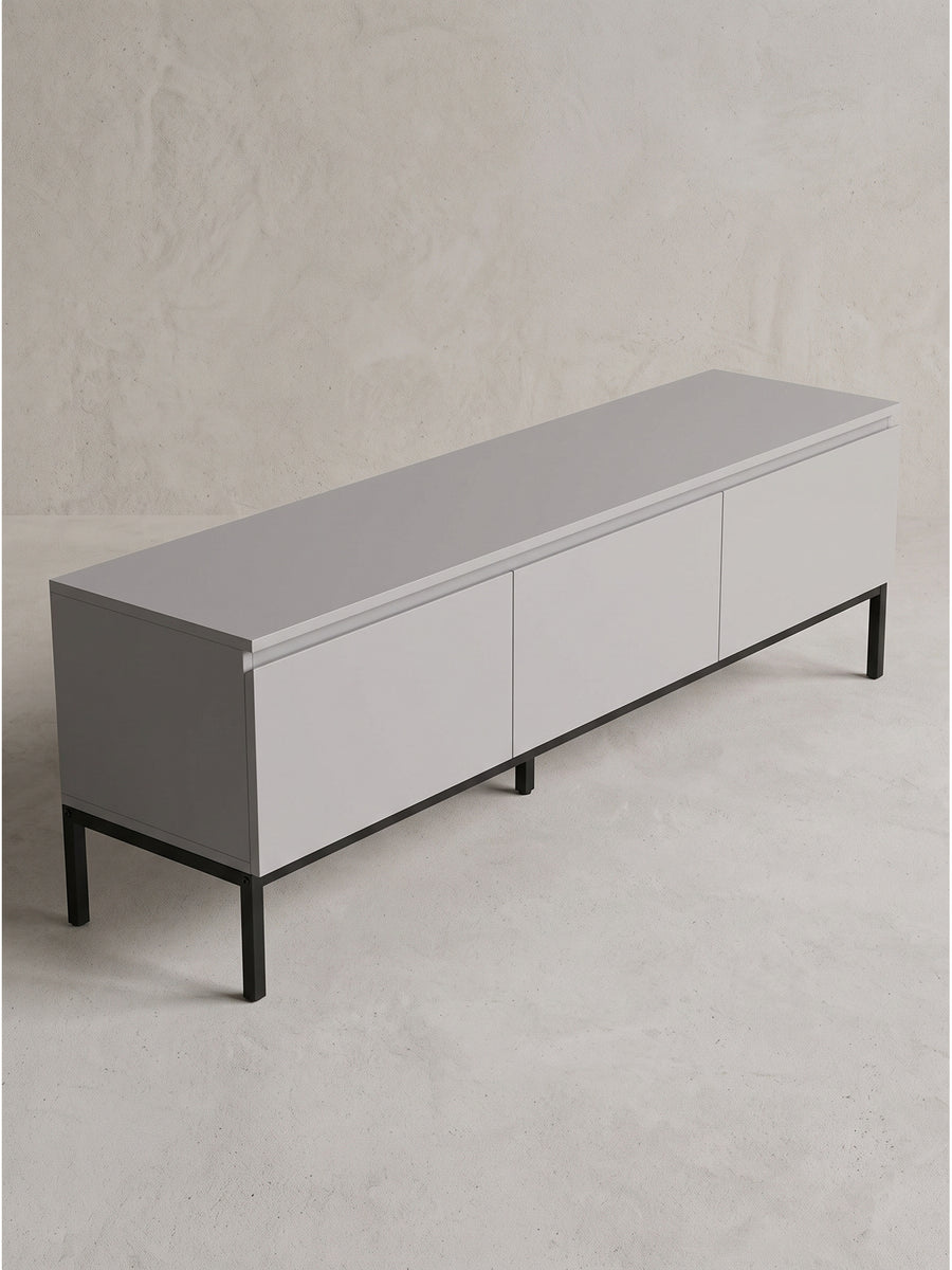 Elegantes graues TV Board mit drei geschlossenen Schubladen in einer seitlichen Perspektive auf sauberem weißem Hintergrund_