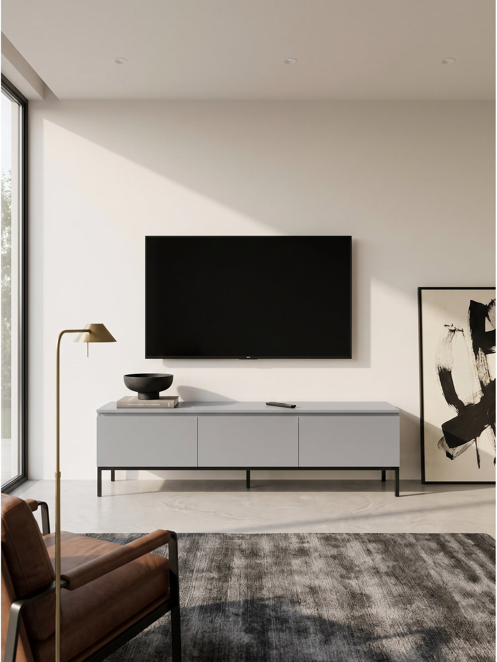 Minimalistisches Lowboard aus grauem MDF mit schwarzem Metallgestell im puristischen Wohnzimmer vor einer glatten weißen Wand_