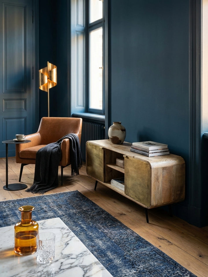 Ein Stapel Kunstbücher und eine Keramikvase stehen auf der Oberfläche einer Fernsehkommode aus Massivholz, die eine wohnliche und stilvolle Atmosphäre im Wohnzimmer schafft._
