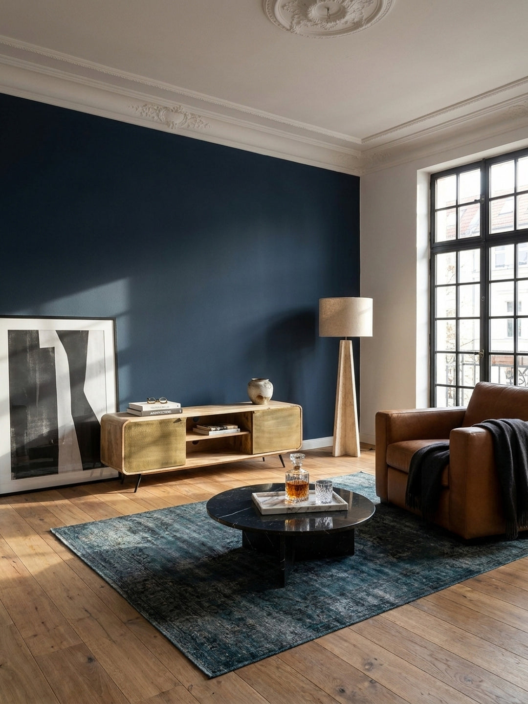 Modernes TV-Lowboard aus massivem Mangoholz mit Messingtüren, zentral platziert in einem Wohnzimmer im Vintage-Modern-Stil mit marineblauer Akzentwand und Eichenparkett._