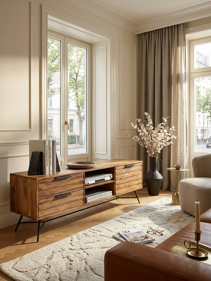 Draufsicht auf das moderne Wohnzimmer mit dem eleganten Sheesham-Massivholz Lowboard. Die 40cm Tiefe bietet perfekten Stauraum für Technik, flankiert von minimalistischem Dekor._