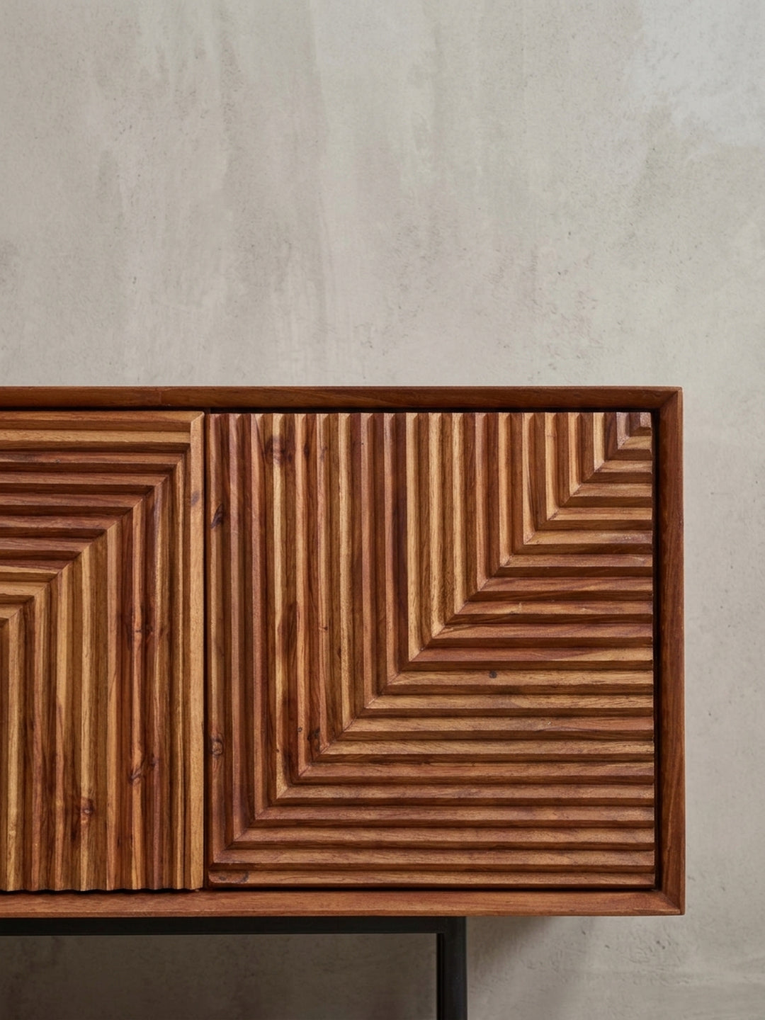 Detailaufnahme der schwarzen T-förmigen Metallfüße, die einen stabilen Stand und einen modernen Kontrast zum Massivholz-Korpus des Lowboards bieten._