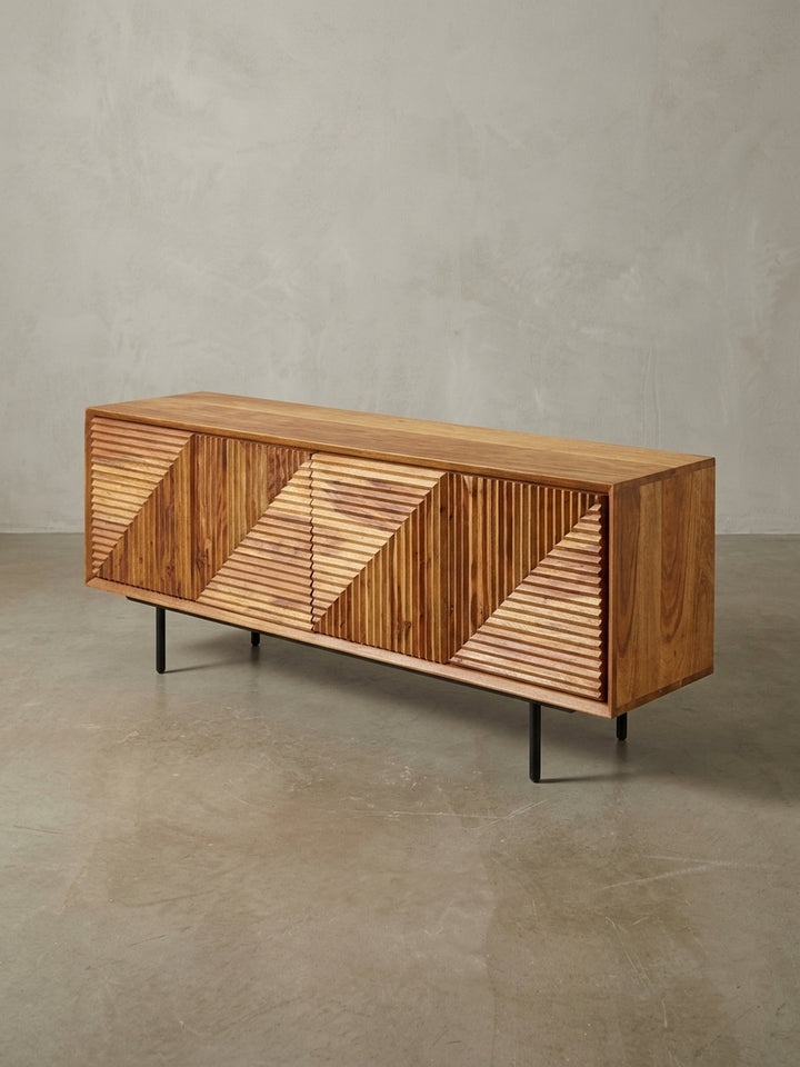 Die Fernsehkommode aus Sheesham-Holz aus einer alternativen Perspektive, die das Zusammenspiel von warmer Holzfarbe und geometrischem Muster betont._