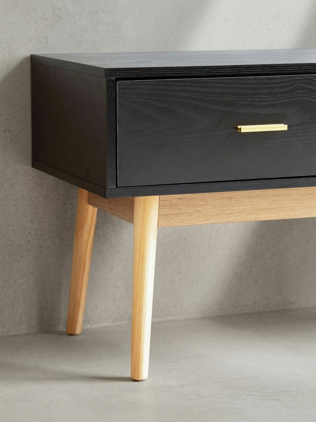 Halbschräge Perspektive auf das TV-Lowboard betont die klaren Linien und die symmetrische Silhouette vor weißem Hintergrund._