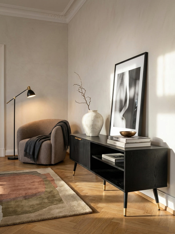 Die TV-Kommode aus Holzwerkstoff mit goldenen Griffen als zentrales Möbelstück in einem gemütlichen Wohnzimmer mit moderner Wandkunst._