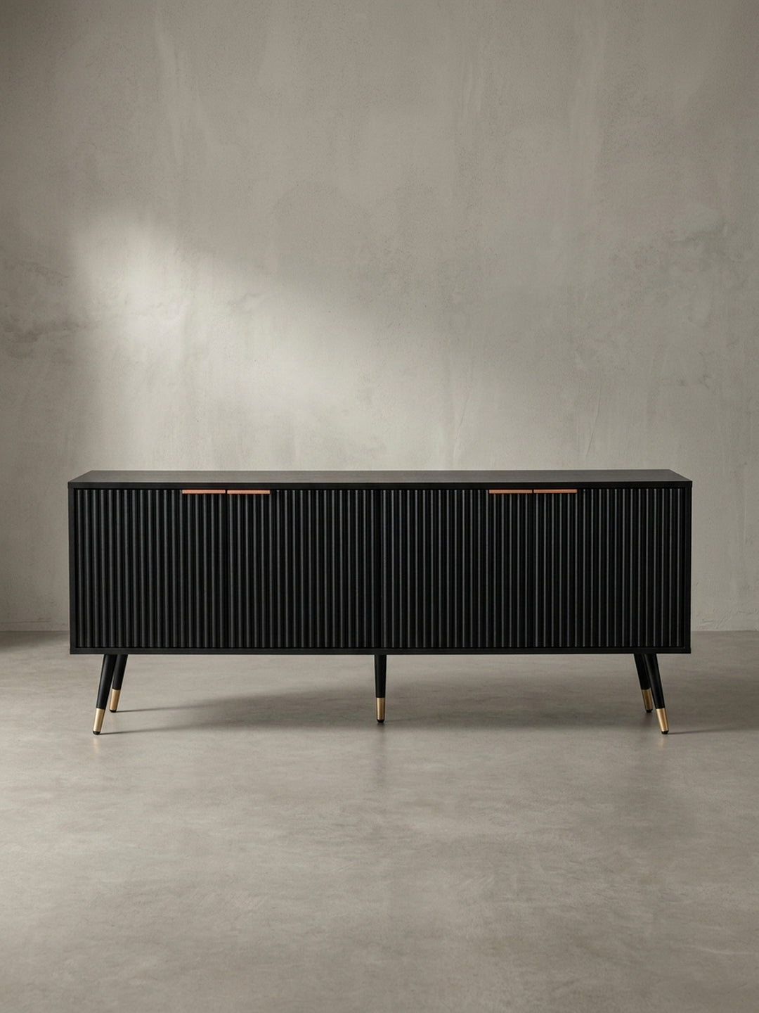 Schräge 3/4-Ansicht des Fernsehschranks in Schwarz, die die Tiefe der Rillenstruktur und die eleganten, ausgestellten Metallbeine zeigt._