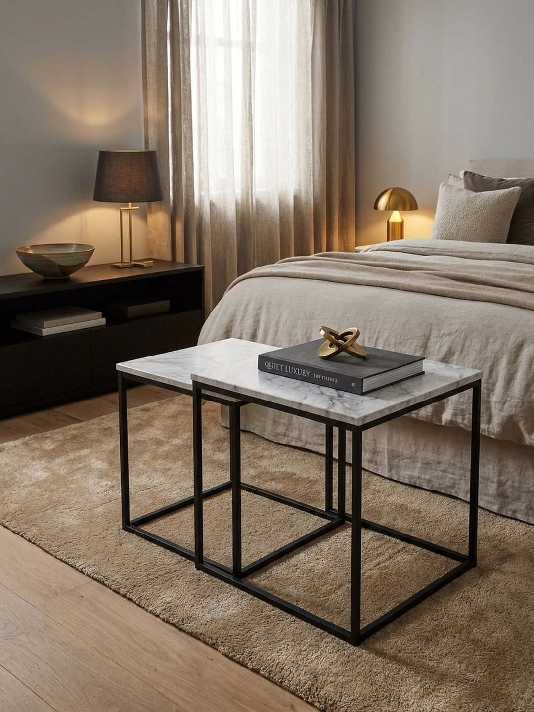 Moderner Satztisch im 2er-Set im Wohnzimmer, mit weißer Marmor-Optik Tischplatte und schwarzem Metallgestell, elegant neben einem beigen Sofa arrangiert._