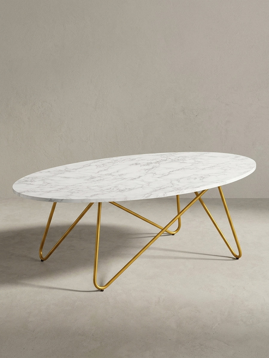 Moderner Loungetisch in ovaler Form aus der 3/4-Ansicht, das skulpturale goldene Metallgestell und die marmorierte Tischplatte sind aus diesem Winkel gut erkennbar._