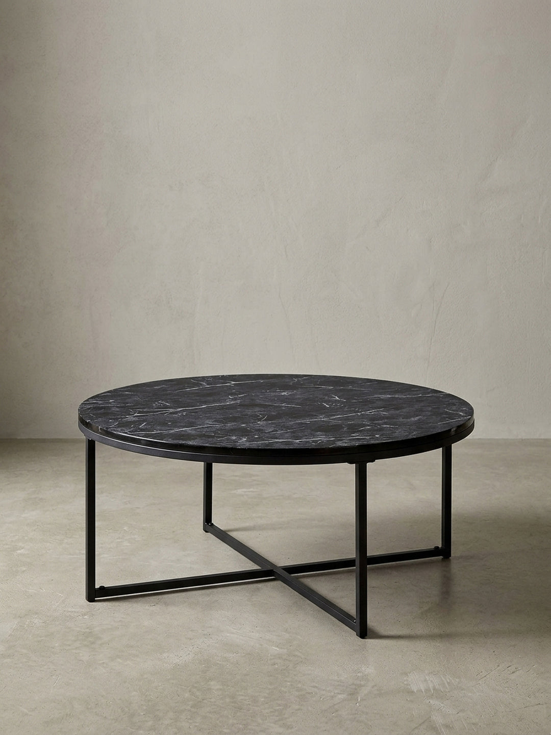 Moderner Couchtisch rund 80 cm mit schwarzer Marmor-Optik Tischplatte und filigranem schwarzem Metallgestell, freigestellt vor weißem Hintergrund._