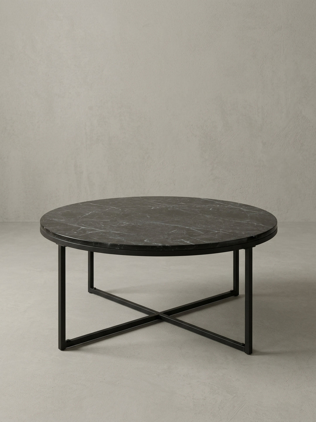 Seitenansicht des 35 cm hohen Sofatischs, der die schlanke Silhouette des schwarzen Metallgestells und die dünne Tischplatte in Marmor-Optik zeigt._