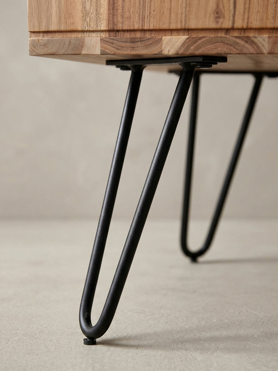 Nahaufnahme des eckigen Stauraums und der Kantenverarbeitung des Akazienholz-Couchtisches, ein Detail der handwerklichen Qualität._