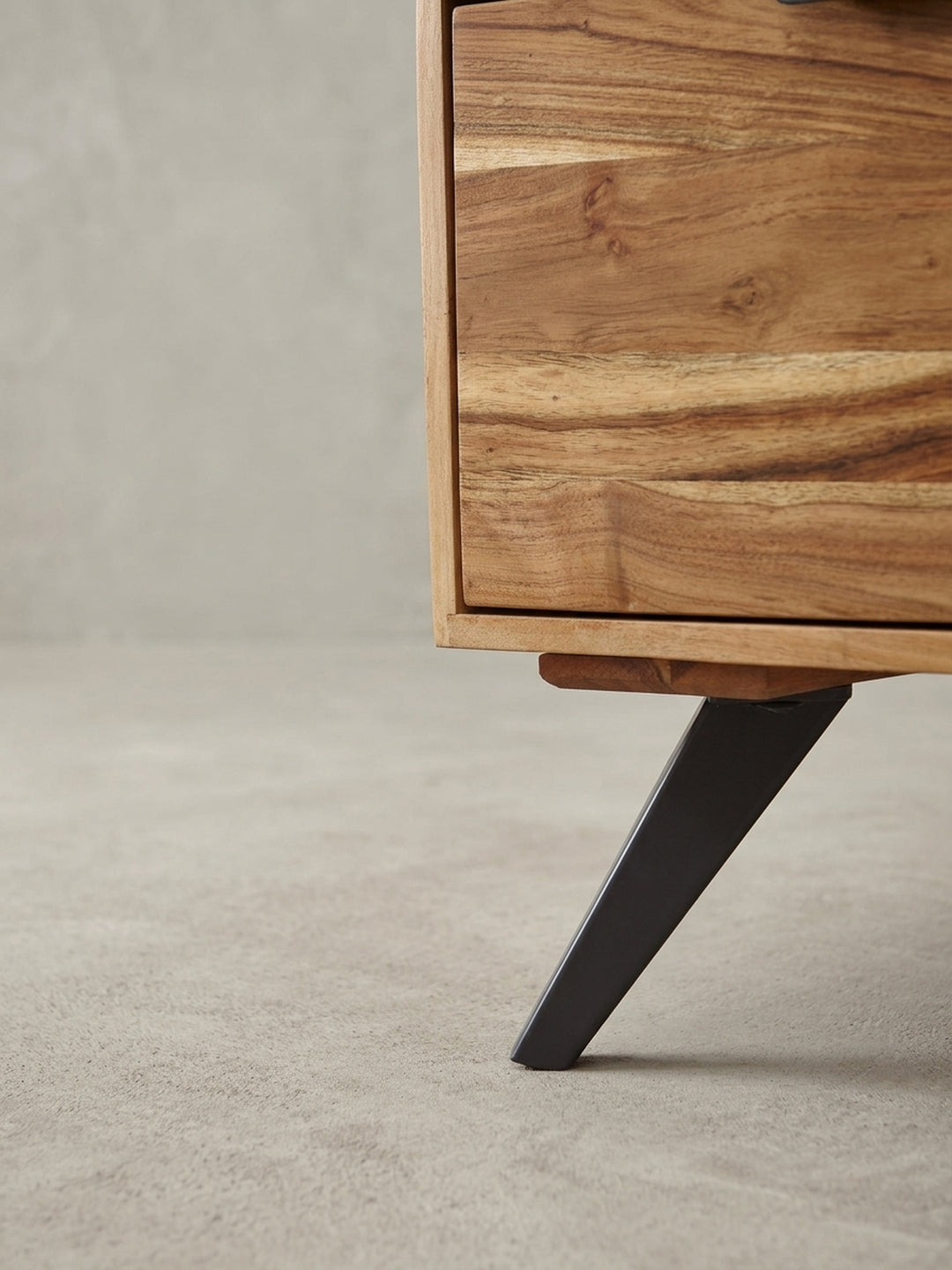 Nahaufnahme des minimalistischen, schwarzen Griffes aus Metall an der Schublade des Couchtisches, der einen modernen Kontrast zur warmen Akazienholz-Oberfläche bildet._