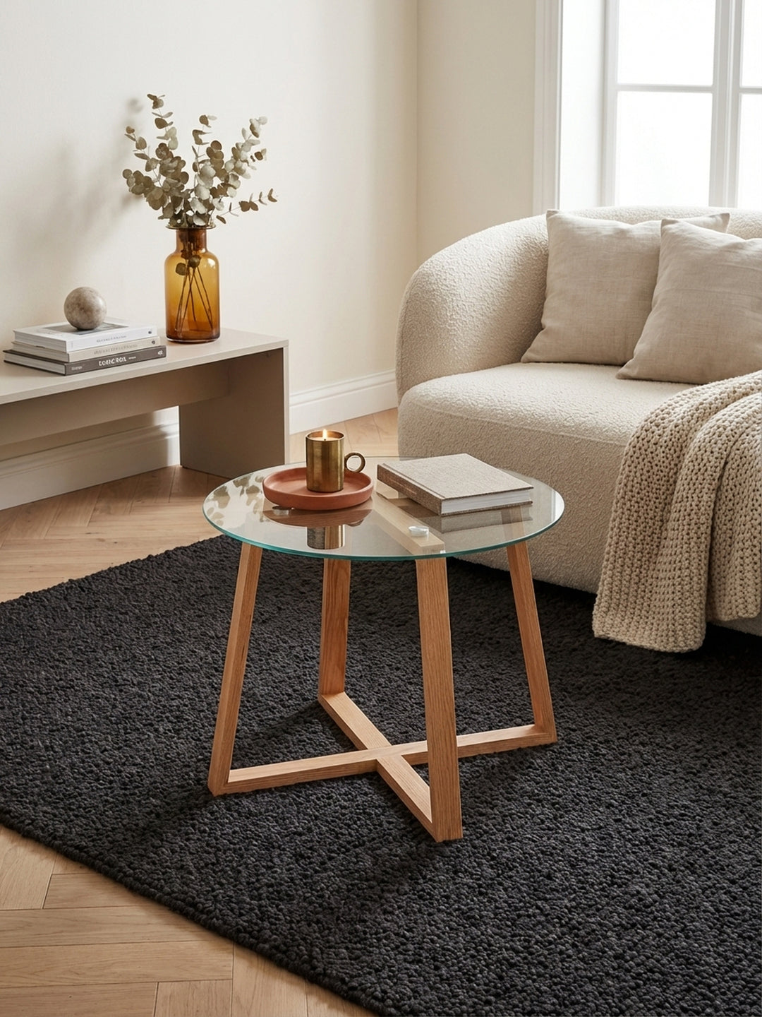 Runder Glas-Couchtisch mit Eiche-Massivholzgestell von oben gesehen. Die Anordnung im Wohnzimmer zeigt die kompakte Größe von 58 cm, ideal als kleiner Beistelltisch._
