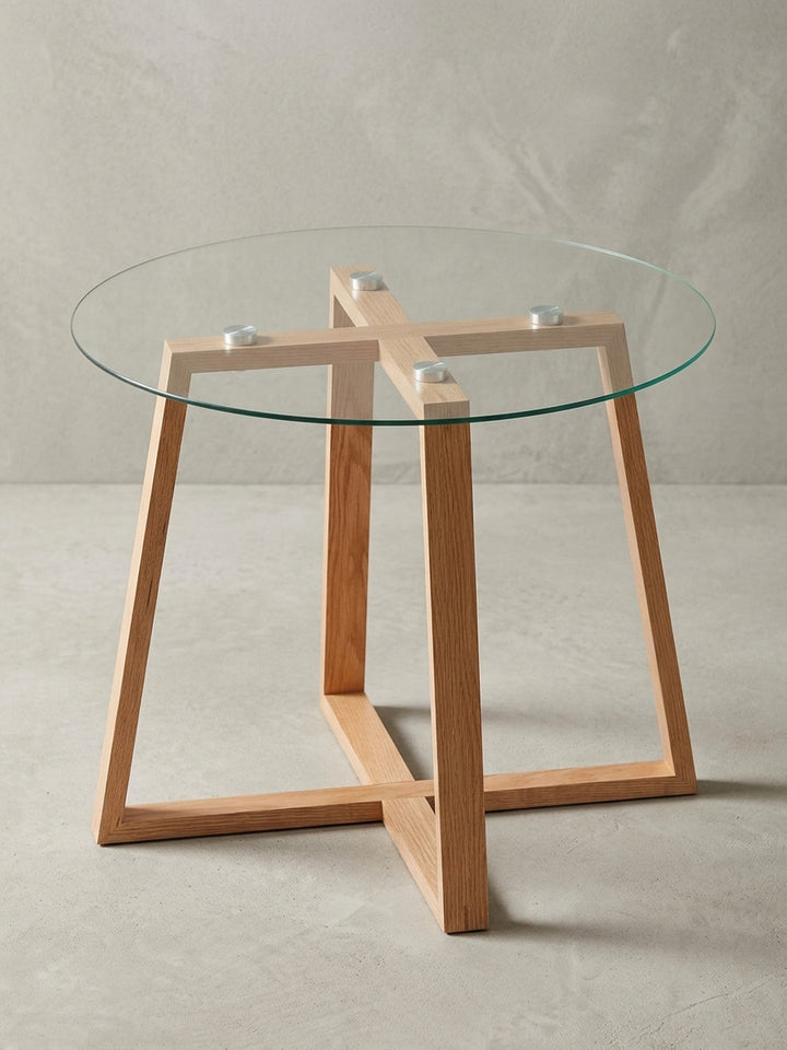 Runder Kaffeetisch aus Glas und Eiche aus einer alternativen Perspektive. Die Befestigung der 58 cm Glasplatte auf dem Massivholzgestell ist durch das Glas sichtbar._
