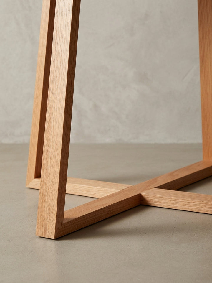 Nahaufnahme der Verbindung zwischen Glasplatte und Eichenholz-Gestell des Sofatisches. Die Metallhalterungen sorgen für sicheren Halt und ein modernes Detail._