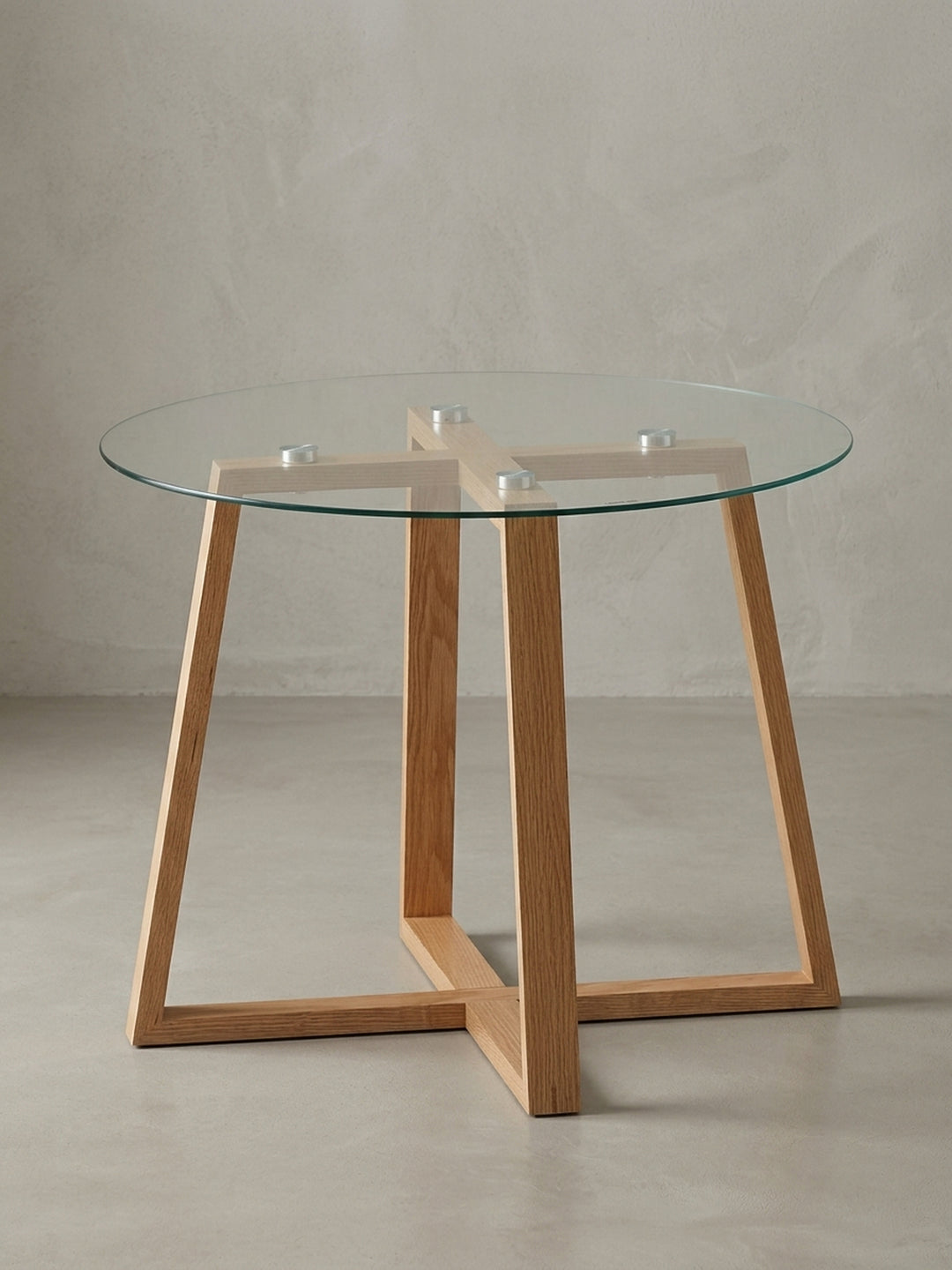 Moderner runder Couchtisch (58 cm) mit Glasplatte und massivem Eichenholzgestell freigestellt vor weißem Hintergrund. Frontansicht des eleganten Designs für das Wohnzimmer._