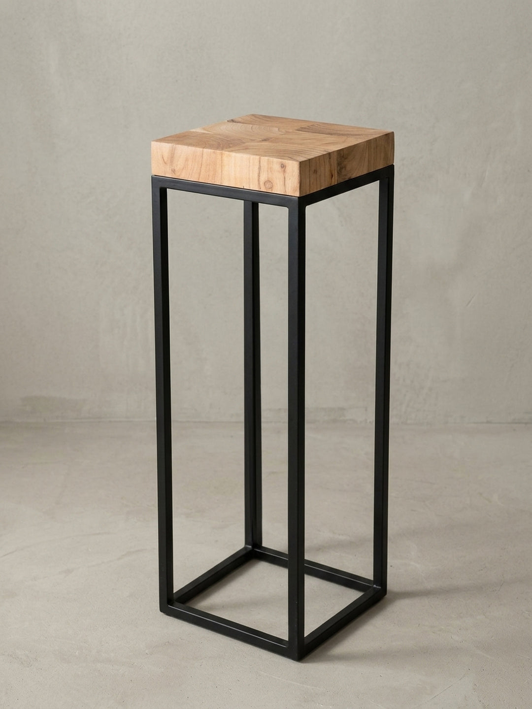 Nahaufnahme des architektonischen Übergangs von der Akazienholz-Platte zum schwarzen Eisengestell. Die Holzkante harmoniert mit dem industriellen, matten Finish des Metalls._
