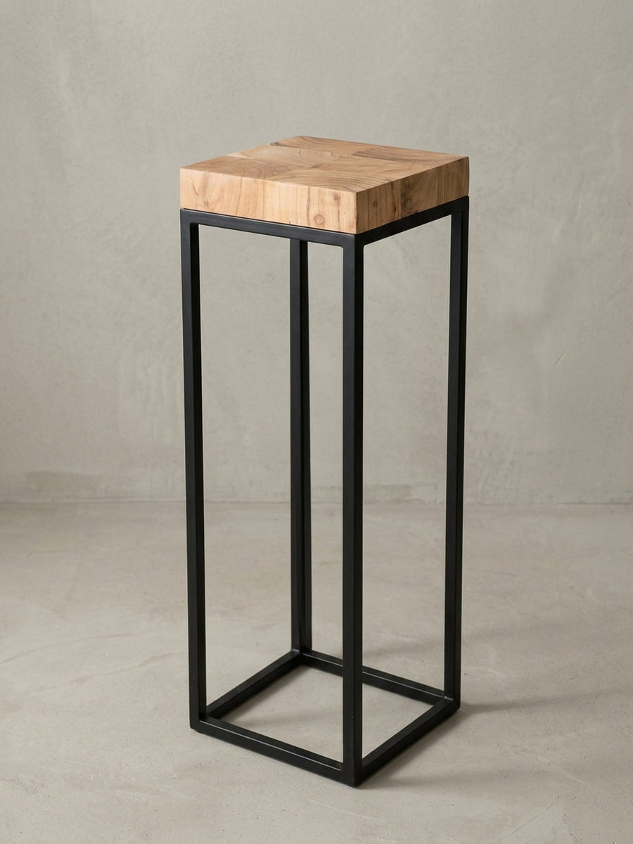 Nahaufnahme des architektonischen Übergangs von der Akazienholz-Platte zum schwarzen Eisengestell. Die Holzkante harmoniert mit dem industriellen, matten Finish des Metalls._