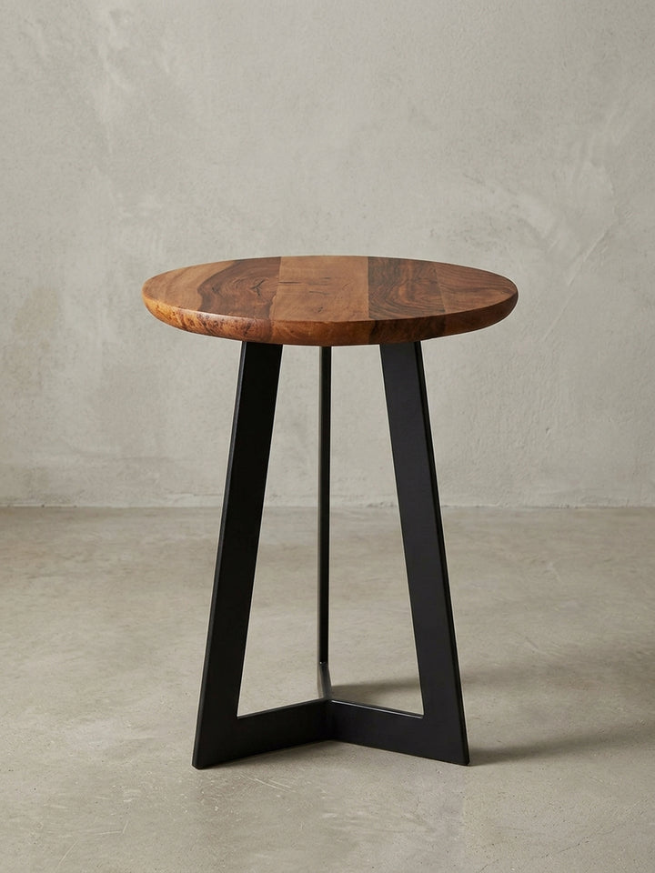 Gesamtübersicht des minimalistischen Dekotisches. Die Kombination aus runder Massivholzplatte und schwarzem Dreibeingestell macht ihn zum perfekten Begleiter für jede Leseecke._