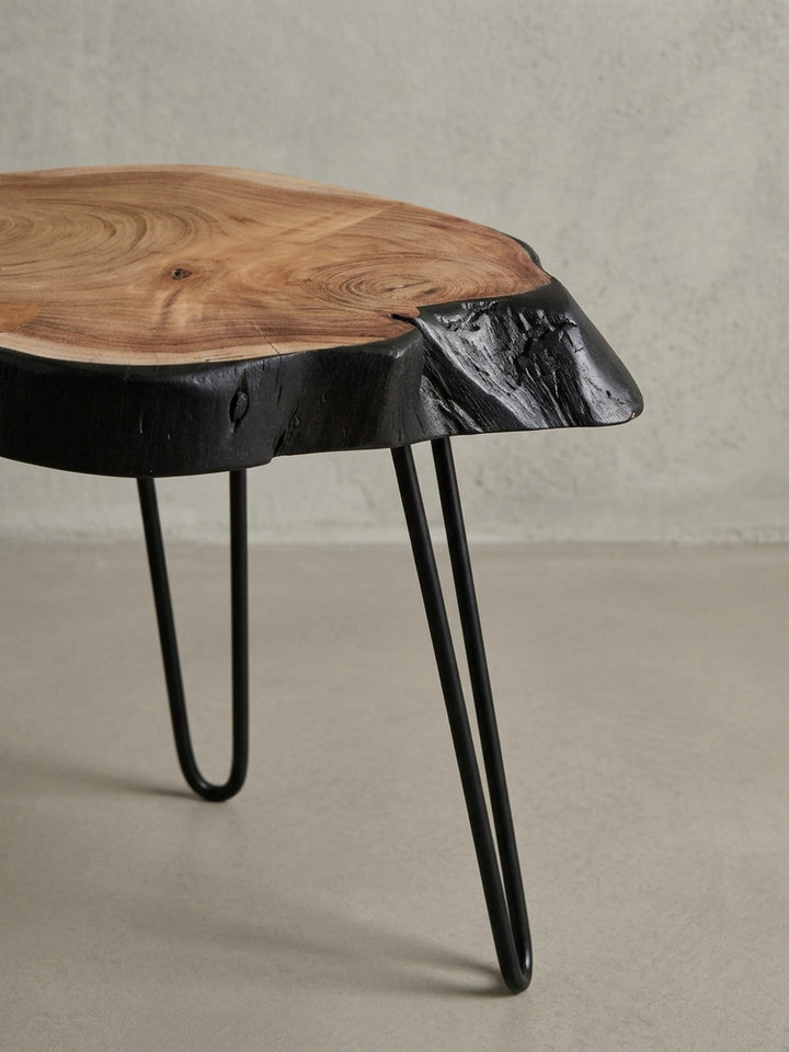 Makroaufnahme einer charakteristischen Spalte in der Akazien-Tischplatte, ein Detail, das die Authentizität des massiven Baumkanten-Beistelltisches unterstreicht._