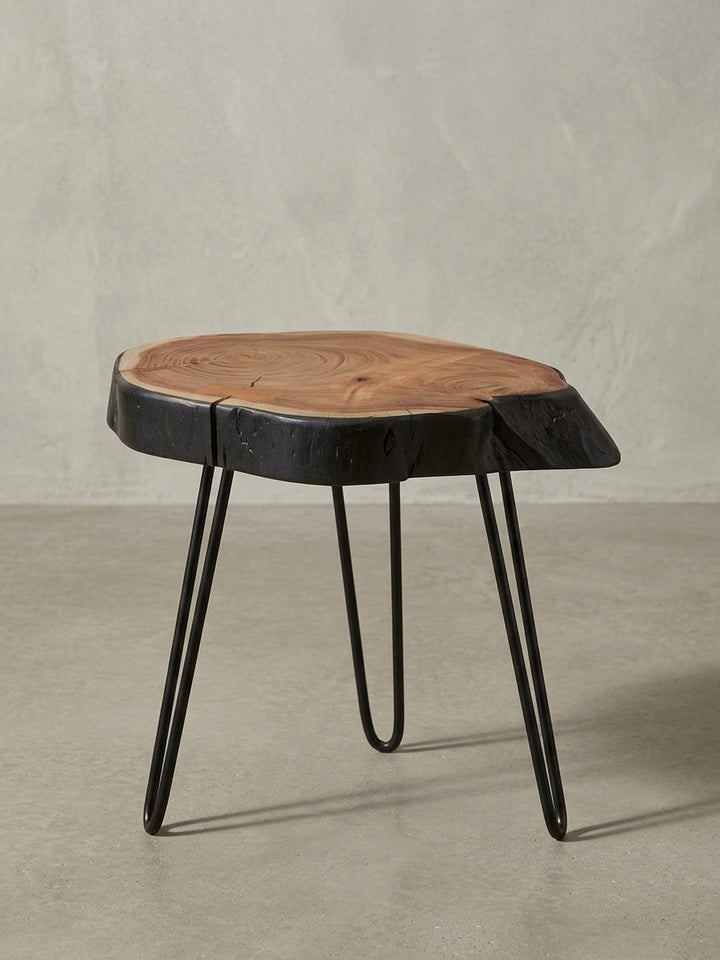 Rustikaler Wohnzimmertisch 40x40x32 cm in 3/4-Ansicht, die organische Form der massiven Akazienholz-Tischplatte und die schwarzen Metallbeine zeigend._