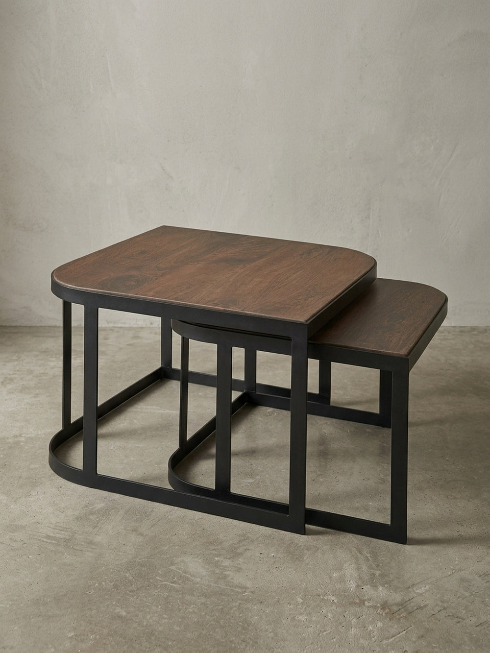 Industrial Couchtisch 2er Set aus massivem Mangoholz auf weißem Hintergrund, Frontansicht des platzsparenden ineinandergeschobenen Designs._