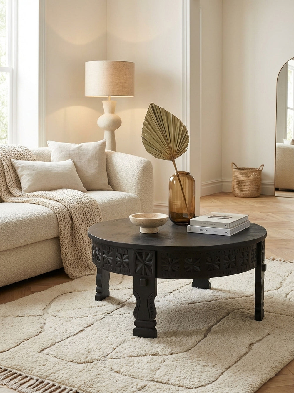 Eleganter runder Couchtisch aus schwarzem Massivholz im orientalischen Stil, stilvoll in einem hellen Wohnzimmer mit einem cremefarbenen Teppich und einem gemütlichen Sofa arrangiert._