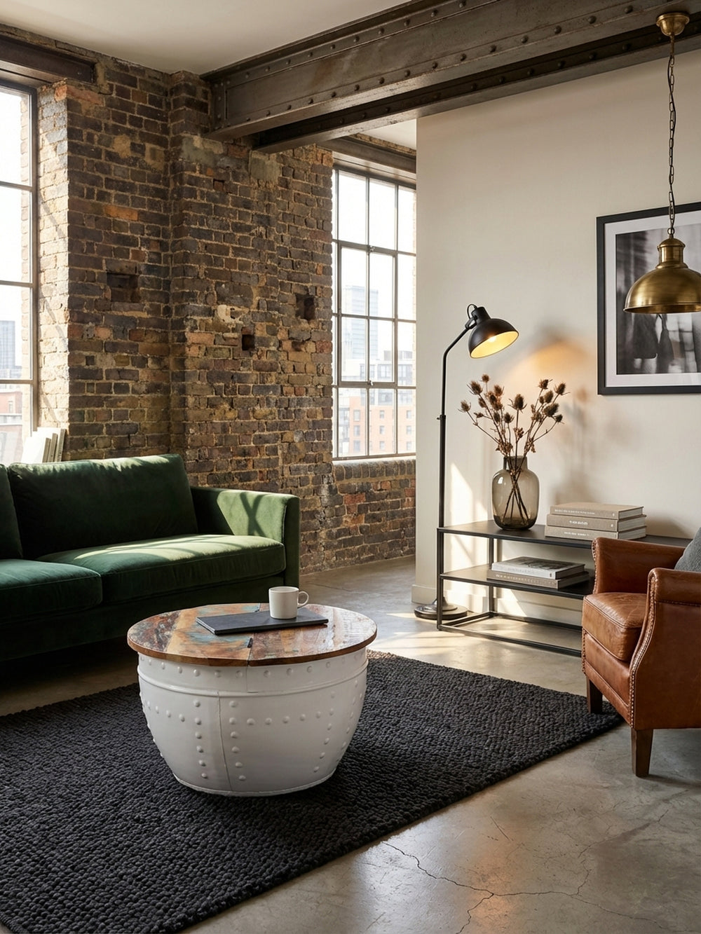 Runder Couchtisch mit Stauraum von oben gesehen, platziert auf einem grauen Teppich vor einer Couch, zeigt die aufklappbare Mango-Holzplatte._