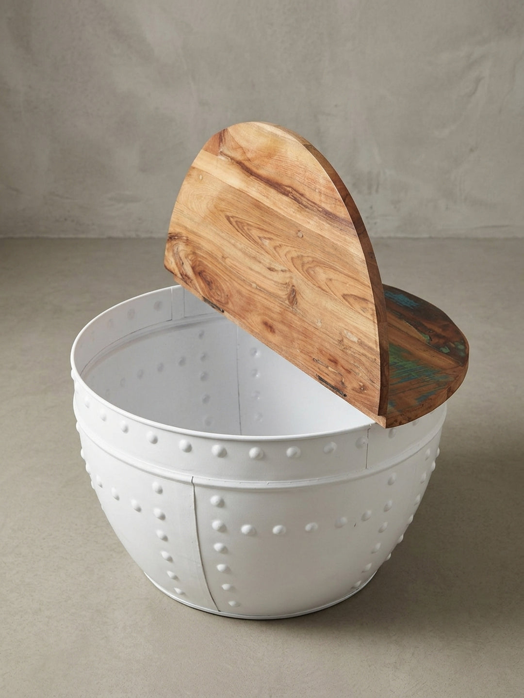 Nahaufnahme der dekorativen Nieten am weißen Eisenkorpus des runden Couchtischs, ein charakteristisches Merkmal des Industrial Designs._